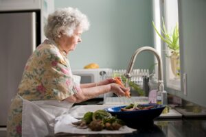 [ an older woman enjoying quiet time in her kitchen]